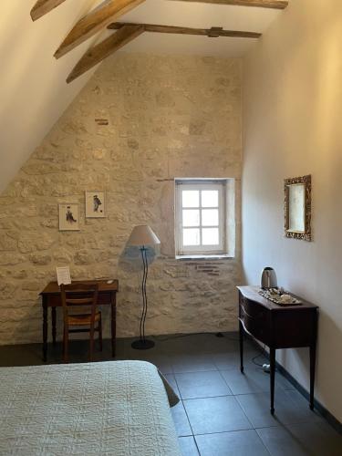 a bedroom with a desk and a bed and a window at L'Ancien Couvent Cahuzac in Cahuzac