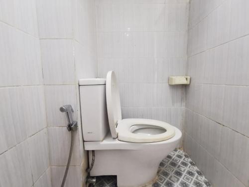 - une salle de bains avec des toilettes blanches dans une cabine dans l'établissement Cibubur Village Wina Property, à Cibubur