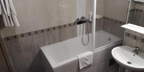 a bathroom with a bath tub and a sink at Hotel Elegance in Belgrade