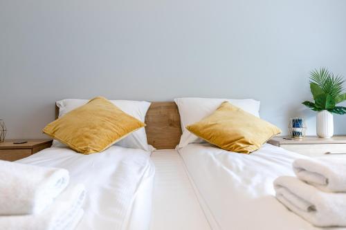 a white bed with two pillows on top of it at Baltica Towers by Symphony Aparthotels in Gdańsk