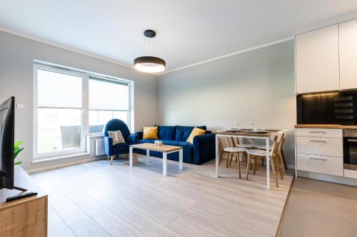 a living room with a blue couch and a table at Baltica Towers by Symphony Aparthotels in Gdańsk