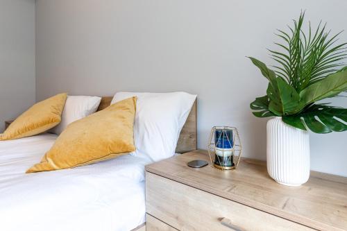 a bedroom with a bed with a vase with a plant at Baltica Towers by Symphony Aparthotels in Gdańsk