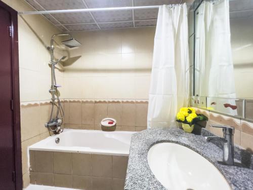 a bathroom with a tub and a sink at Luxury two bedroom شقة فخمة وكبيرة غرفتين in Ajman 