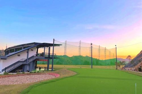 einen Golfplatz mit einem Gebäude und einem Grün in der Unterkunft HỒNG PHƯƠNG HOTEL in Cao Bằng