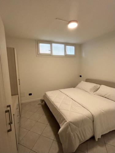 a bedroom with a white bed and a window at Holiday Sweet Apartment in Malcesine