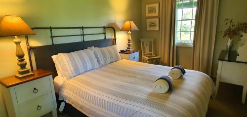 a bedroom with a large bed with towels on it at Old Schoolmaster's Cottage on the Barrington River in Barrington