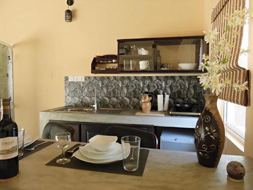 a kitchen with a table with plates and a bottle of wine at Nayan's Paradise in Kottanitivu