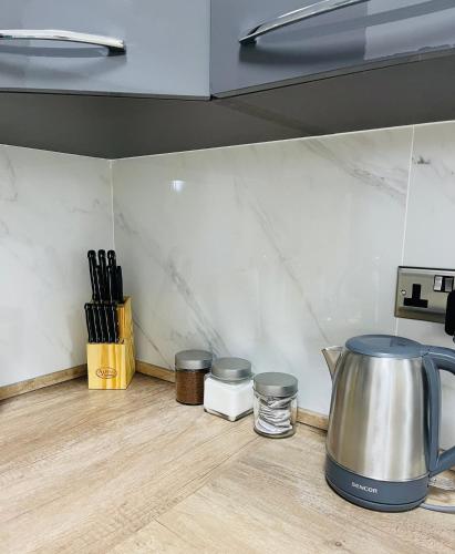 a kitchen counter with a tea kettle and utensils at New, Modern Ground Floor Apartment with Pool in Għajnsielem