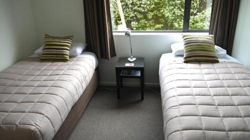 2 Betten in einem Zimmer mit Fenster in der Unterkunft Darfield Motel in Darfield