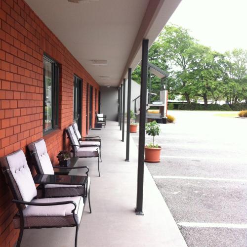 a row of chairs sitting on the side of a building at Darfield Motel in Darfield