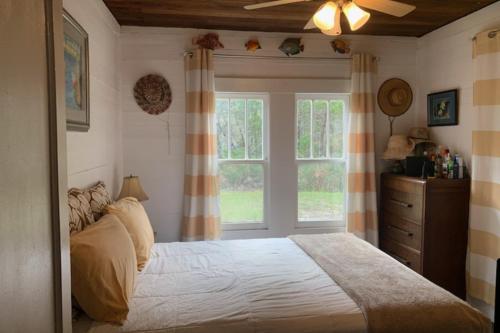 Un dormitorio con una cama grande y una ventana en Diver Down Cottage, en Carrabelle