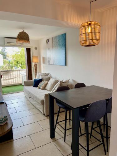 un salon avec une table et un canapé dans l'établissement La Frégate - appartement à 100 m de la plage, à Saint-Cyr-sur-Mer