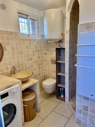 uma casa de banho com um WC, um lavatório e uma máquina de lavar roupa em La Frégate - appartement à 100 m de la plage em Saint-Cyr-sur-Mer