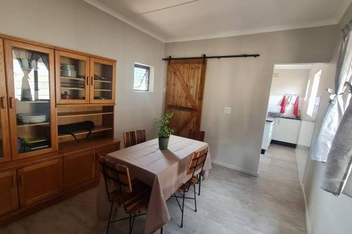 a dining room with a table and some chairs at Rock away Beach Condo. in Hartenbos