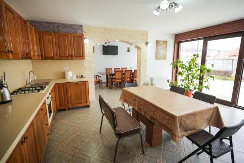 cocina y comedor con mesa y sillas en Aldevis House, en Horezu