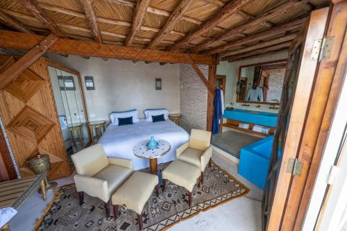 1 dormitorio con 1 cama, mesa y sillas en Sultana larache en Larache