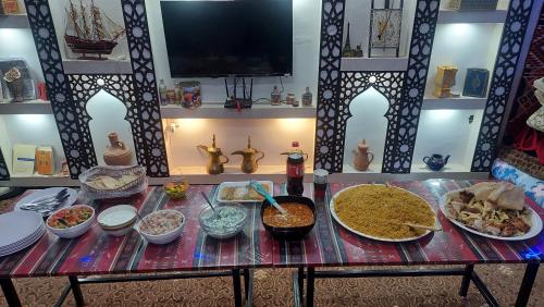 a table with many different dishes of food on it at Wadi Rum Oryx Hostel & Tours in Wadi Rum