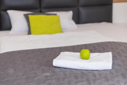 a green apple sitting on top of a pile of towels on a bed at Boardinghouse HOME - adults only - in Konstanz