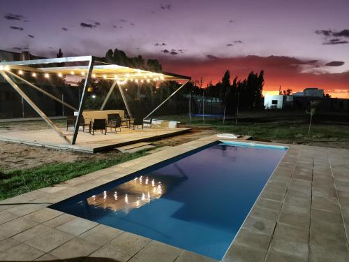 a swimming pool with a tent and a table and chairs at Complejo Koi in General Alvear