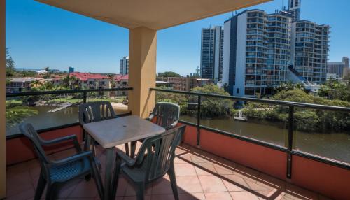 a balcony with a table and chairs overlooking a river at Paradise Island Resort in Gold Coast