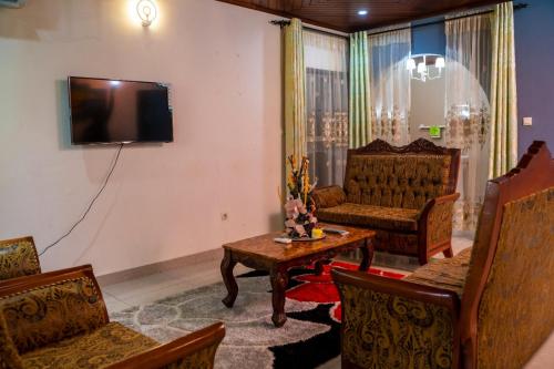 ein Wohnzimmer mit einem Sofa und einem TV in der Unterkunft Plan B Complex in Buea