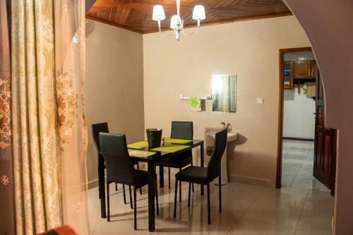 a dining room with a black table and chairs at Plan B Complex in Buea