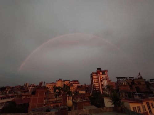 a group of buildings with a rainbow in the sky at Yog Hostel- Rooftop Yoga & Backpacker Social Stay in Thamel, Kathamndu in Kathmandu
