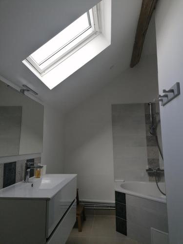 a bathroom with a sink and a skylight at Chez Mary in Soisy-sur-École