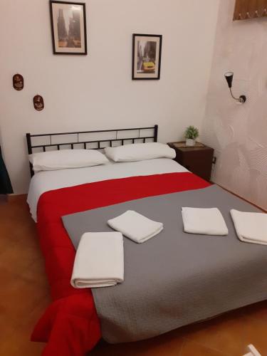 una camera da letto con un grande letto con lenzuola bianche e rosse di Casa Normanna a Salerno