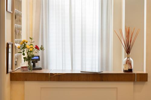 una finestra con fiori in un vaso su uno scaffale di Hotel Cimabue a Firenze
