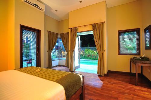 1 dormitorio con 1 cama con paredes y ventanas de color amarillo en Villa Rona Pererenan, en Canggu