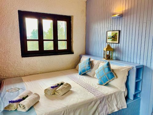 a bed with two towels on it with a window at Panoramic View Village of Villa Luigina Cortona in Castiglion Fiorentino
