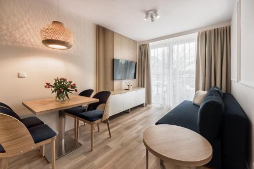 a living room with a couch and a table at Aurum Aparthotel - Nowe Apartamenty blisko Plaży - Neue Appartements in Strandnähe in Świnoujście