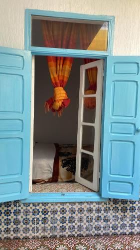 a small room with a bunk bed with a window at Riad chez brahim in Essaouira
