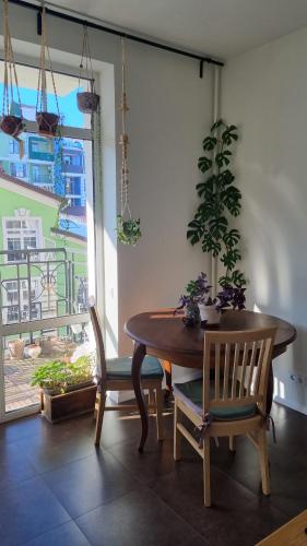 a dining room with a table and chairs and a window at Kyiv Jungle apartment in Kyiv