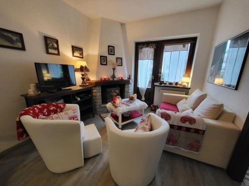 a living room with white furniture and a tv at Casa Vacanze in Morgex
