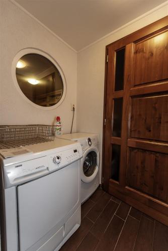 a laundry room with a washing machine and a mirror at Hilltop Wellness Villa-big garden, sauna, hot tube in Pécs