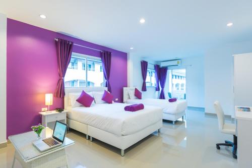 1 dormitorio con 2 camas y un ordenador portátil en una mesa en Z by Zing en Jomtien Beach