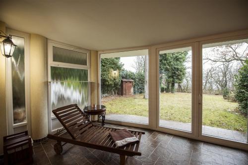 a screened in porch with a bench and windows at Hilltop Wellness Villa-big garden, sauna, hot tube in Pécs