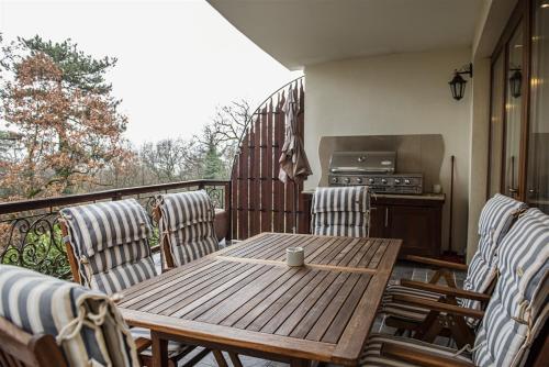 a wooden table and chairs on a balcony at Hilltop Wellness Villa-big garden, sauna, hot tube in Pécs