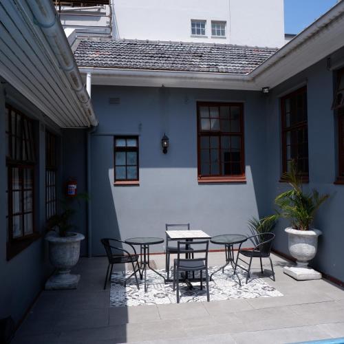 a patio with a table and chairs in front of a building at The City Club in Cape Town