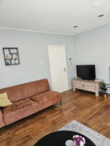 a living room with a couch and a flat screen tv at Vakantiehuis in Oosterwolde