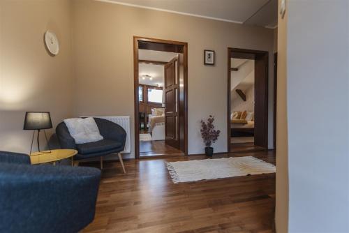 a living room with a blue couch and a chair at Hilltop Wellness Villa-big garden, sauna, hot tube in Pécs