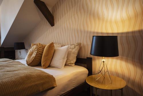 a bedroom with a bed with a lamp and pillows at Hilltop Wellness Villa-big garden, sauna, hot tube in Pécs
