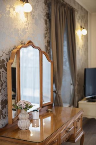 a wooden dresser with a mirror on top of it at Hilltop Wellness Villa-big garden, sauna, hot tube in Pécs