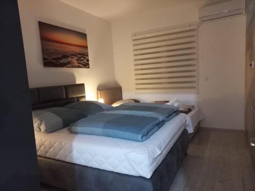 a bedroom with a large bed with blue pillows at Ulcinj Apartments in Ulcinj