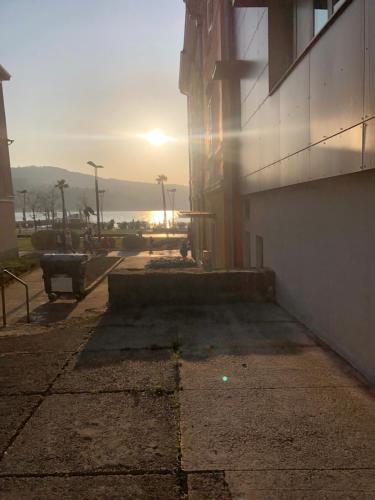 a building with the sun setting in the background at Apartma Sunlight in Koper