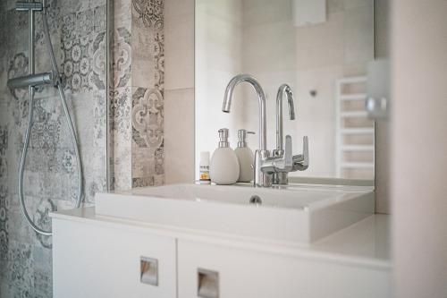 a white bathroom with a sink and a shower at Schettereggerhof in Egg