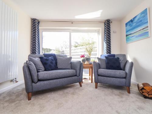 two chairs and a table in a living room with a window at Pickney House in Looe