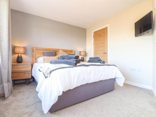 a bedroom with a large bed and a television at Pickney House in Looe